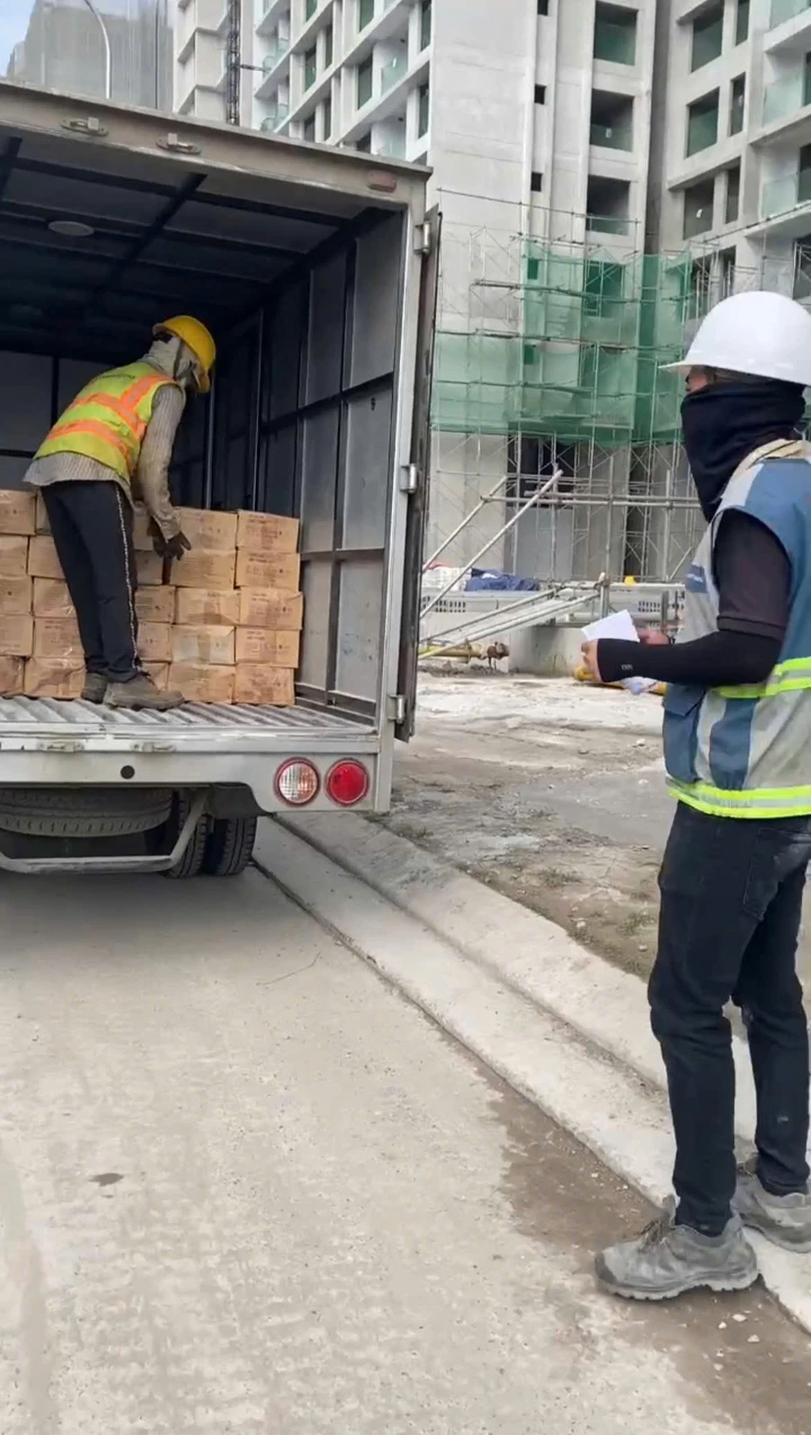 Công nhân bốc dỡ các thùng con kê bê tông Phú Long An tại công trường
